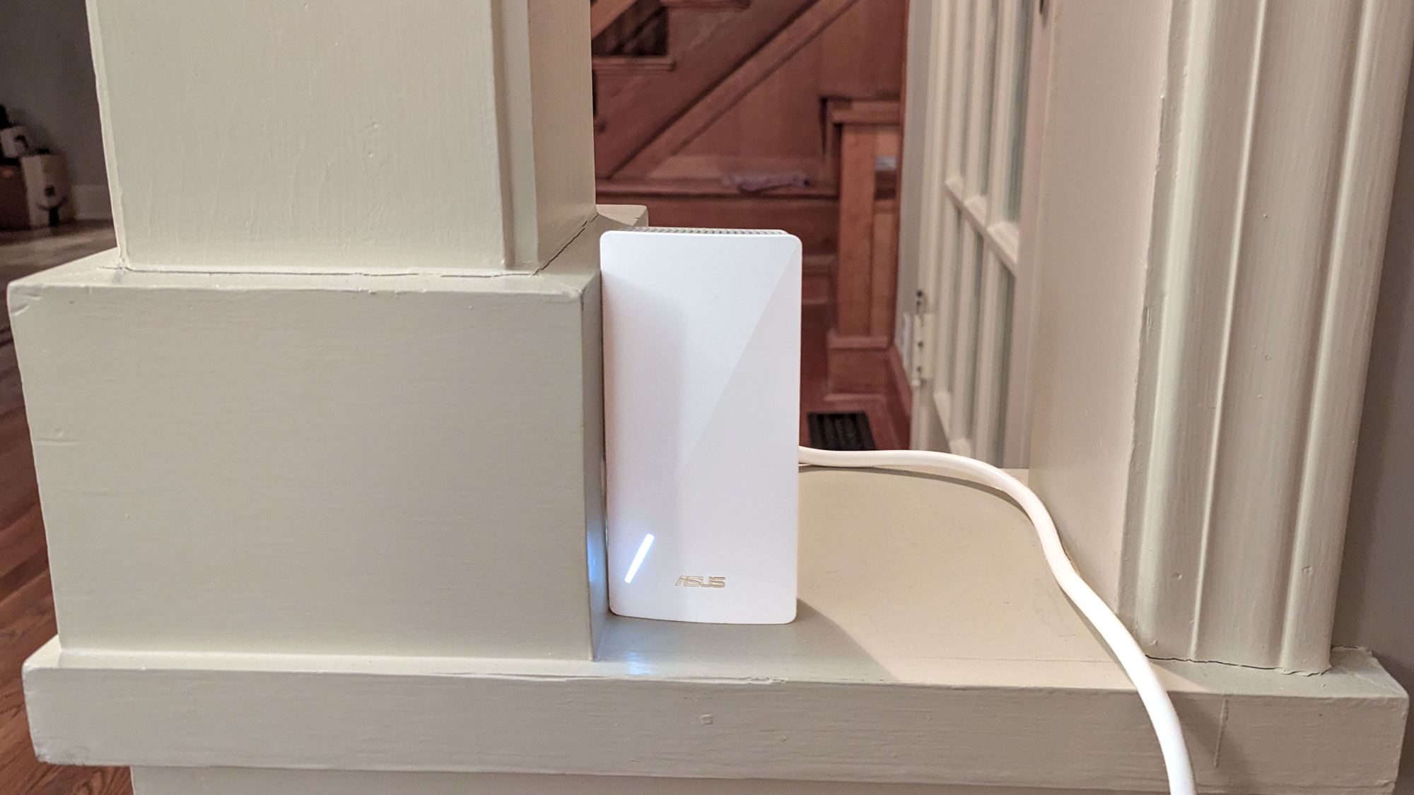 An Asus RP-AX58 Wi-Fi 6 extender on a shelf.