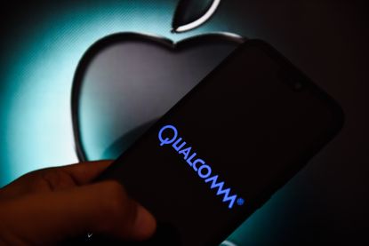 PORTO, PORTUGAL - 2019/04/15: In this photo illustration a Qualcomm logo seen displayed on a smart phone with Apple logo on the background. (Photo Illustration by Omar Marques/SOPA Images/Lig