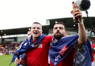 Paul Mullin and Elliott Lee of Wrexham celebrate promotion into League One following the Sky Bet League Two match between Wrexham and Forest Green Rovers at Racecourse Ground on April 13, 2024 in Wrexham, Wales. (Photo by Charlotte Tattersall/Getty Images) (Photo by Charlotte Tattersall/Getty Images)