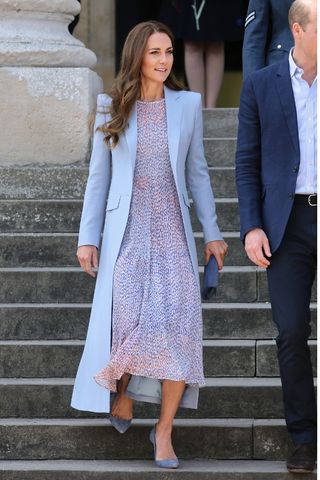 Kate Middleton wears a blue coat, a floral dress and blue heels as she departs the Fitzwilliam Museum during an official visit to Cambridgeshire on June 23, 2022 in Cambridge, England.
