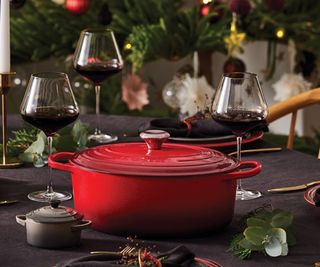 A Le Creuset Dutch Oven in the center of a Christmas table.