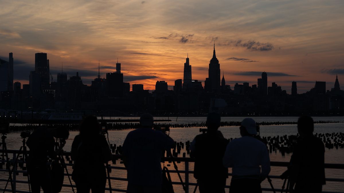 Photographers line up in Jersey City to capture the sunrise eclipse over Manhattan's iconic skyline on June 10, 2021, as seen by Tayfun Coskun.