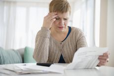 Older woman looked worried while reading paperwork