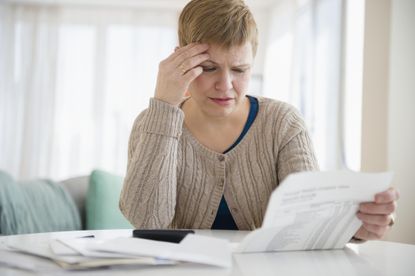 Older woman looked worried while reading paperwork