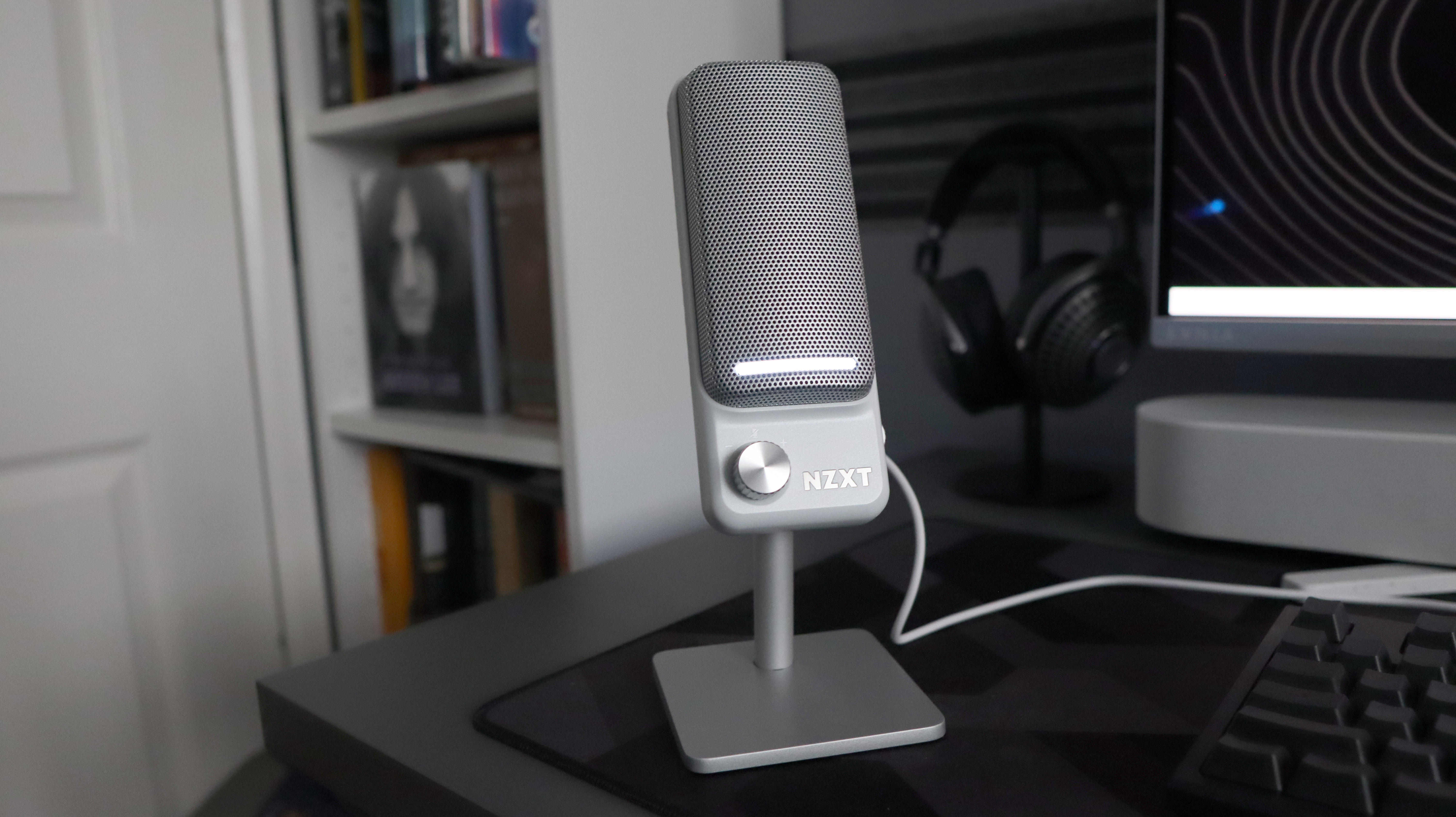 An NZXT Capsule Elite microphone set up on a desk with lighting enabled.