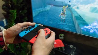 En Nintendo Switch-spiller, der bruger Joy-Con-controllerne til at spille Breath of the Wild på et tv