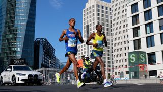 Ethiopia's Guye Adola (R) competes to win ahead of Kenya's Bethwel Yegon (L) during the Berlin Marathon on September 26, 2021 in Berlin.
