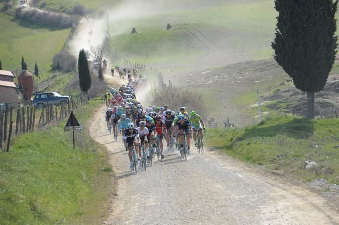 The peloton in action on the signature white gravel roads at Strade Bianche
