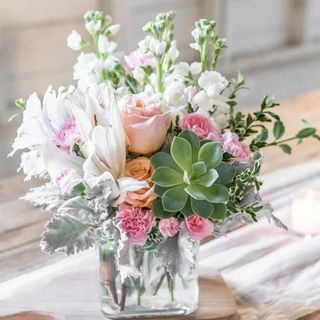 A Southern Peach bouquet of Peach Roses, White Asiatic Lilies, and Echeveria in a glass jar vase