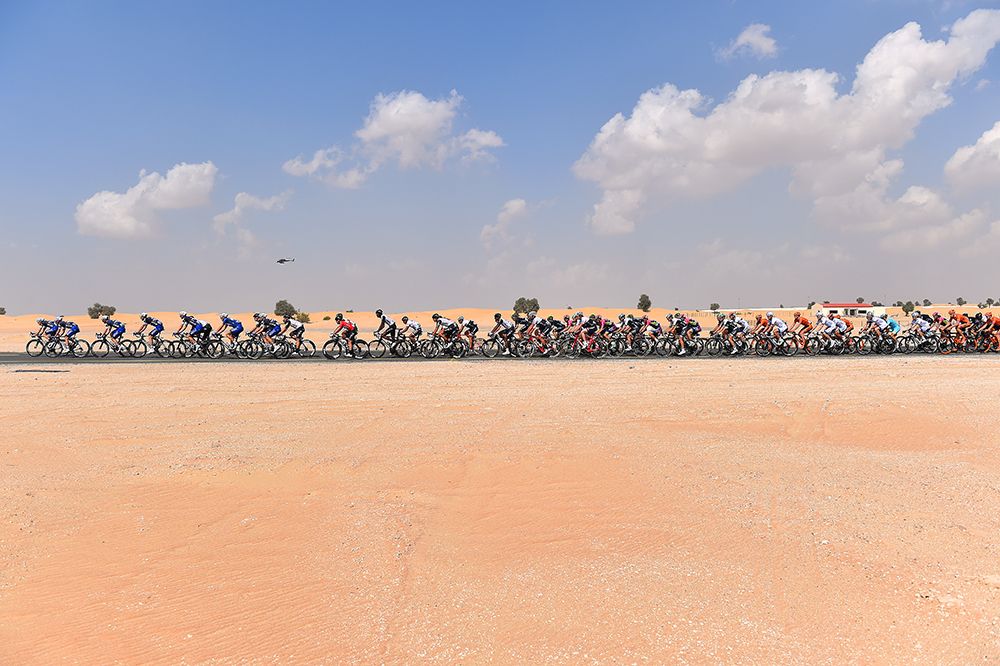 The peloton passes through the desert