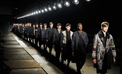 Male models on the catwalk in a line
