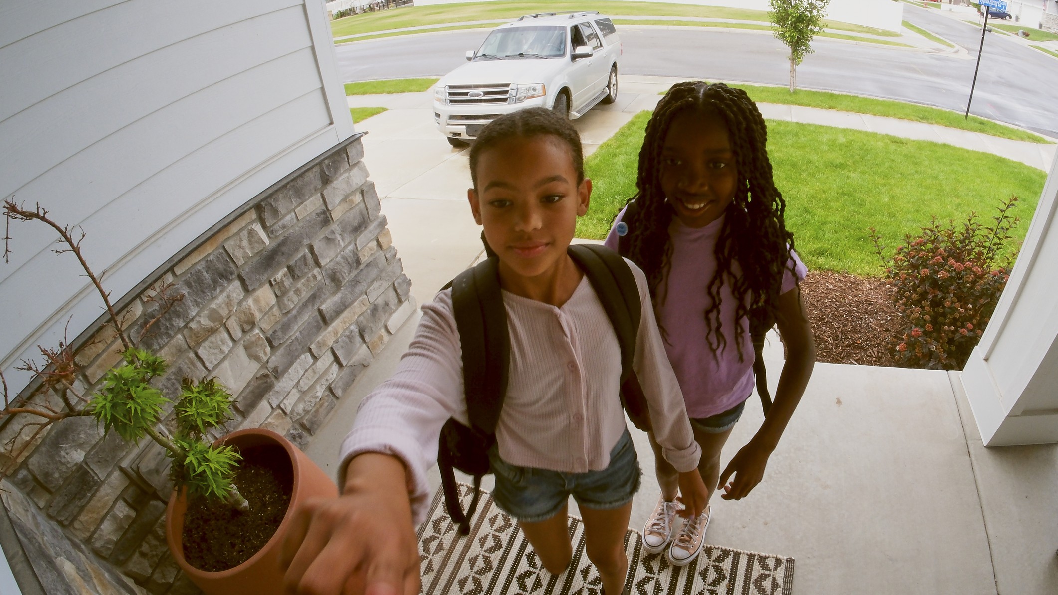 Two children ringing video doorbell