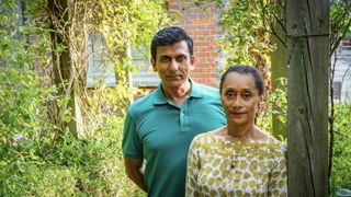 Ace Bhatti, in a green top as Dickie Dent, stands with Suzanne Packer, in a green leafy top as Olivia Dent, by a tree in Midsomer Murders