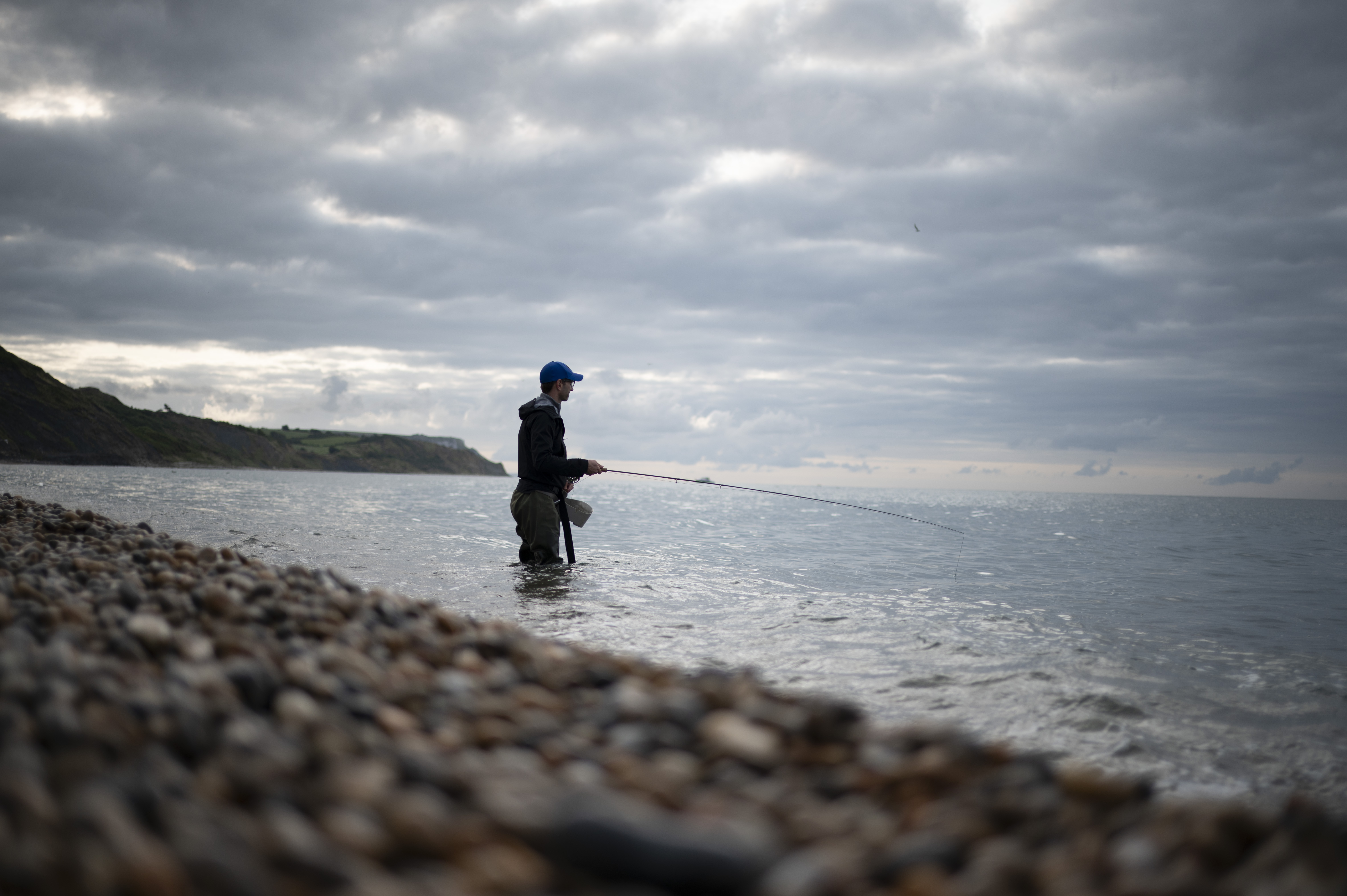 Silhouette of a fisherman knee deep in the ocean, taken with the Nikon Z 35mm f/1.4 lens