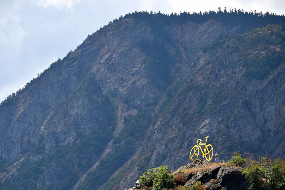 A yellow bike rests at the top of a hill along the route of stage 19