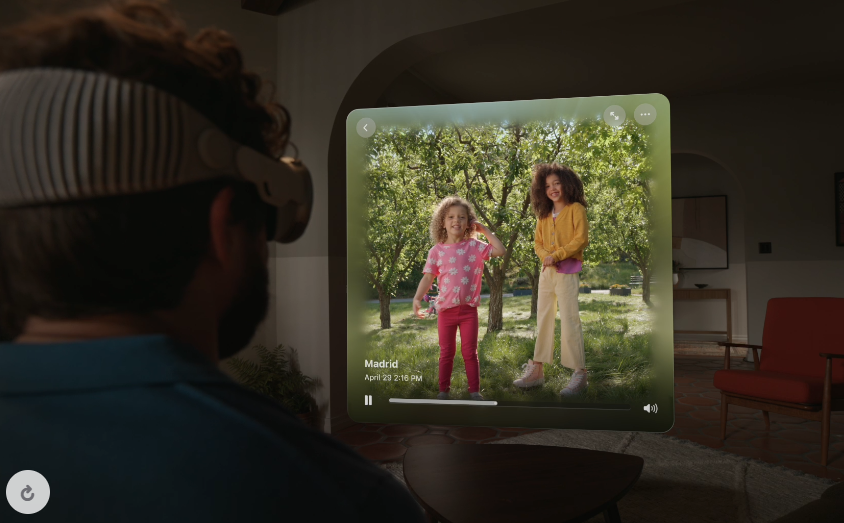 A man uses the Apple Vision pro to watch a video of his children.