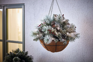 festive hanging basket with red berries and pine cones