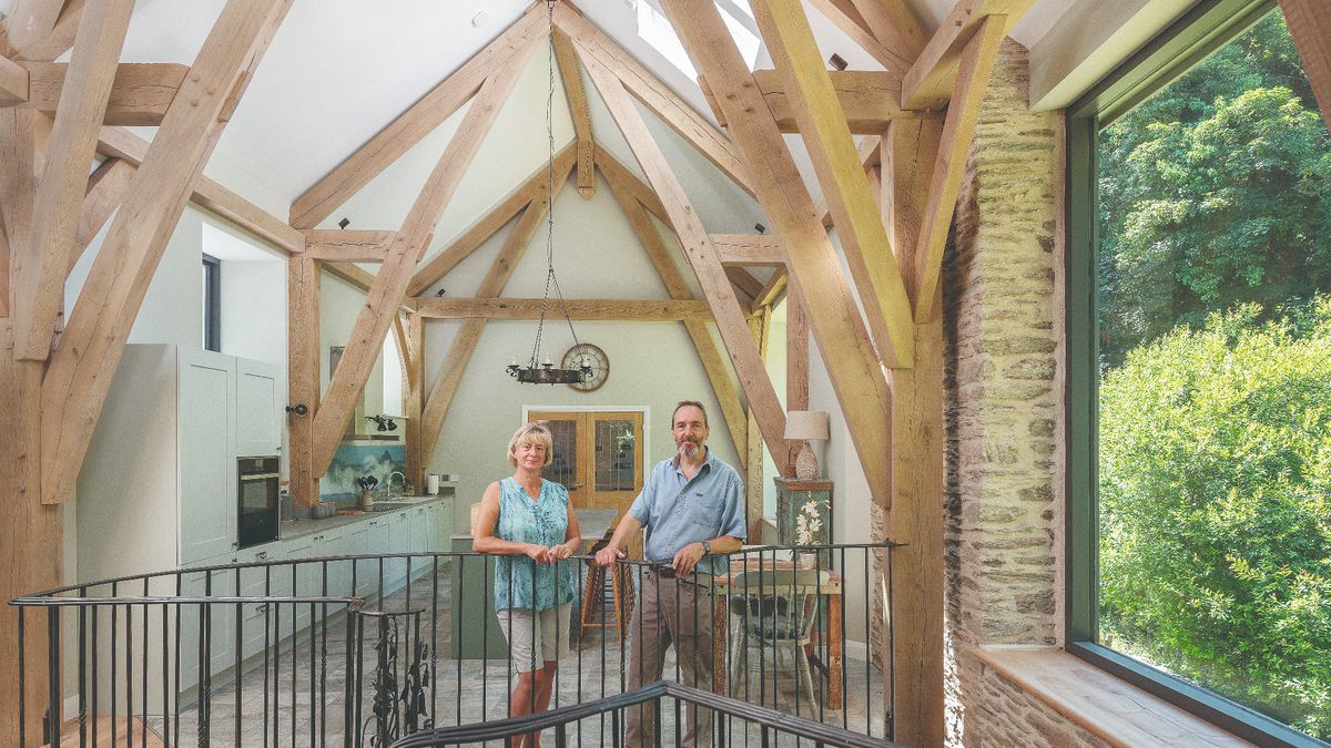 couple standing in a kitchen inside a modern barn conversion 