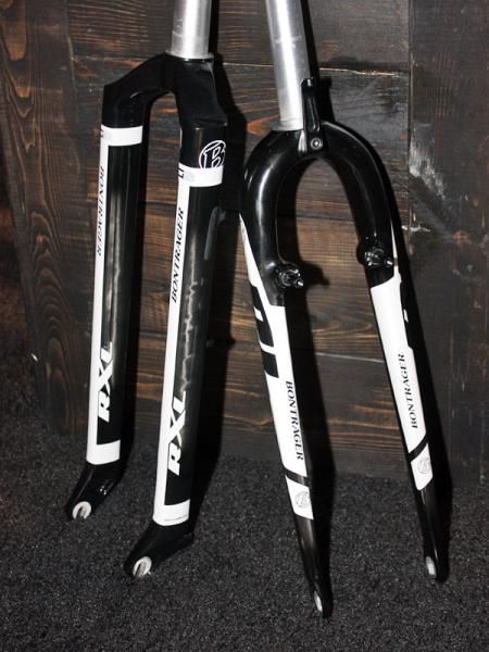 The updated Bontrager Race X Lite Switchblade rigid carbon fiber mountain bike fork (left) uses a reverse-bonded aluminum crown that reduces weight by 250g relative to last year. A crown-mounted cable hanger on the Race Lite CX fork dramatically cuts down on cantilever brake chatter - a far-too-common affliction on race-level 'cross bikes.