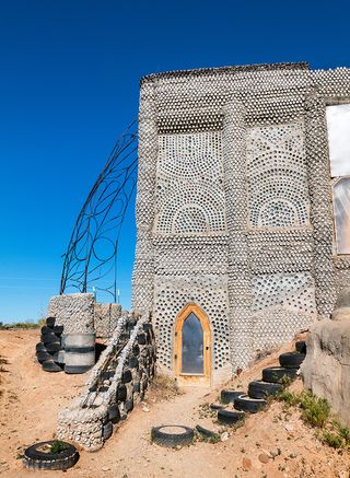 Earthship community in Taos showing colourful off grid homes nestled into the desert earth