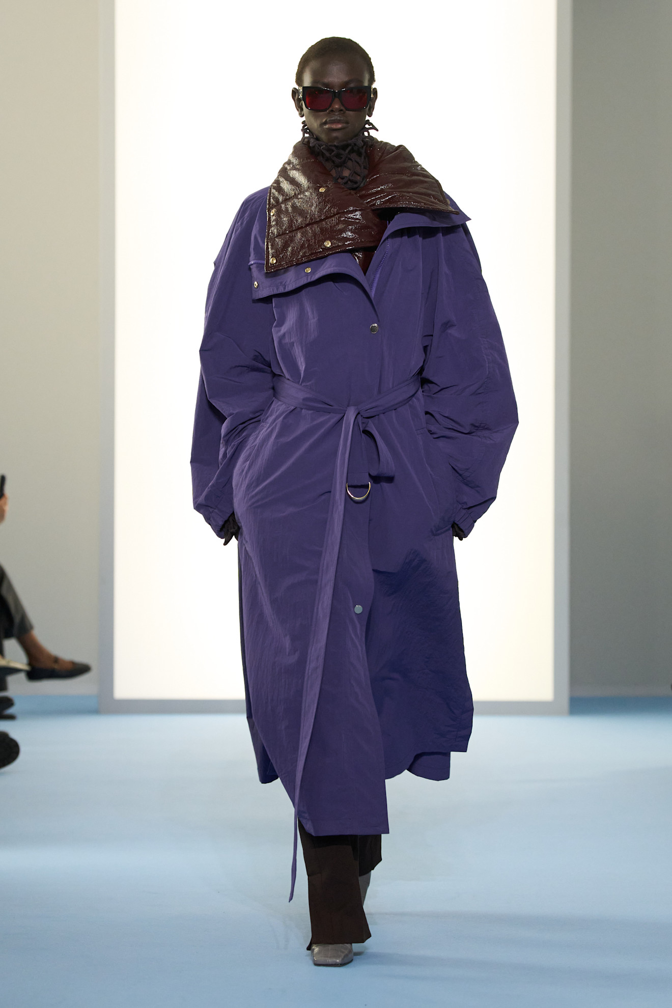 Model wears dark purple on the AW26 runway.