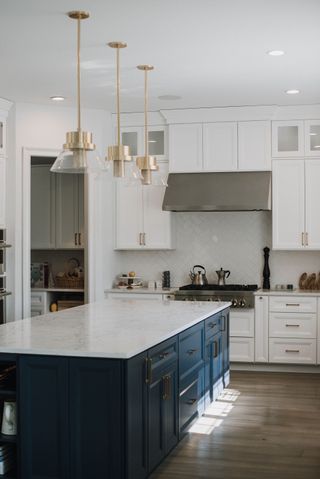 kitchen with blue island and white cabinets wood effect floor