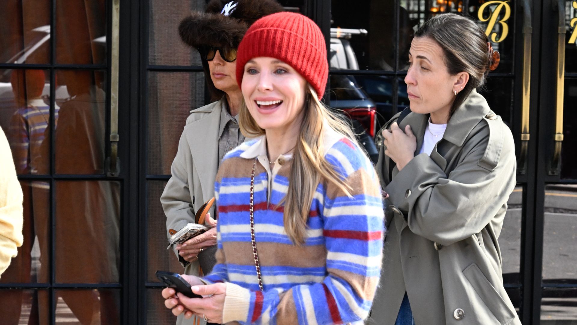 Kristen Bell walks outside wearing a striped polo jumper with indigo jeans, a burgundy Chanel bag and black slim-line leather trainers.