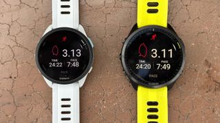 The Garmin Forerunner 165 and 965 side-by-side on a bench, two of the best GPS smartwatches for accuracy.