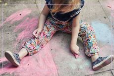 child chalking on the pavement