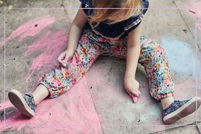 child chalking on the pavement