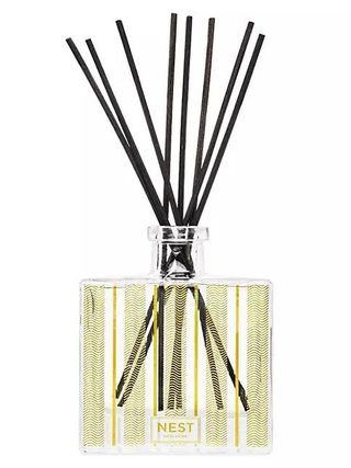 A square glass bottle with black reeds 