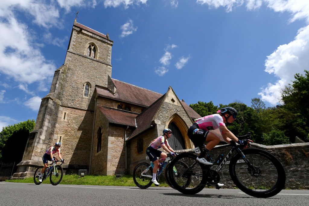 GLOUCESTER ENGLAND JUNE 08 LR Elise Chabbey of Switzerland Alice Barnes of United Kingdom and Team CanyonSram Racing and Lorena Wiebes of Netherlands and Team DSM pink points leader jerseycompete passing through Holy Jesus Church in Lydbrook village during the 8th The Womens Tour 2022 Stage 3 a 1079km stage from Tewkesbury to Gloucester WomensTour UCIWWT on June 08 2022 in Gloucester England Photo by Justin SetterfieldGetty Images