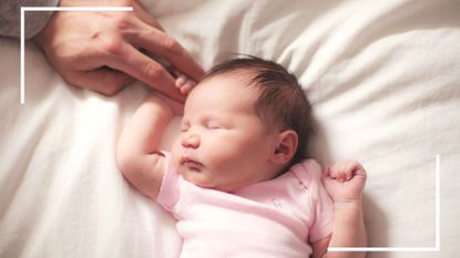 "When do babies sleep through the night?" illustrated by a sleeping baby holding her father's hand