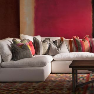 White l-shaped sofa with colourful striped throw pillows