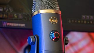 A microphone with colorful lights around the volume control and a gold band