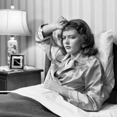 Women in bed with headache - black and white