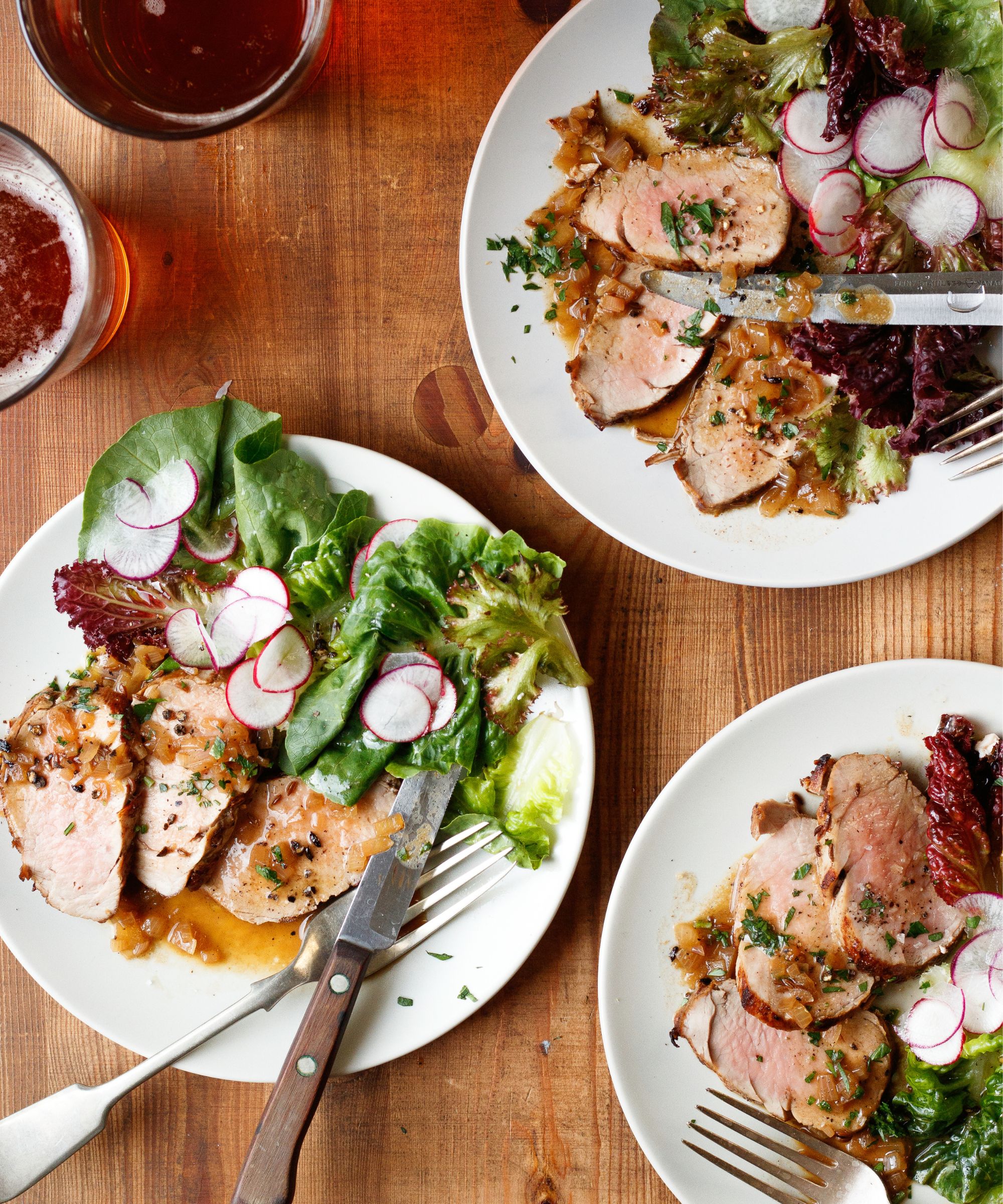 3 plates of pork tenderloin served with salad and radish slices