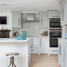 White kitchen with island and built in appliances