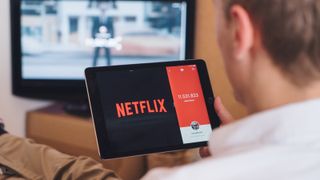 Man watching Netflix on iPad, how to set up iPad VPN