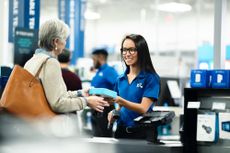 A Best Buy employee assists a senior customer with a purchase in store.