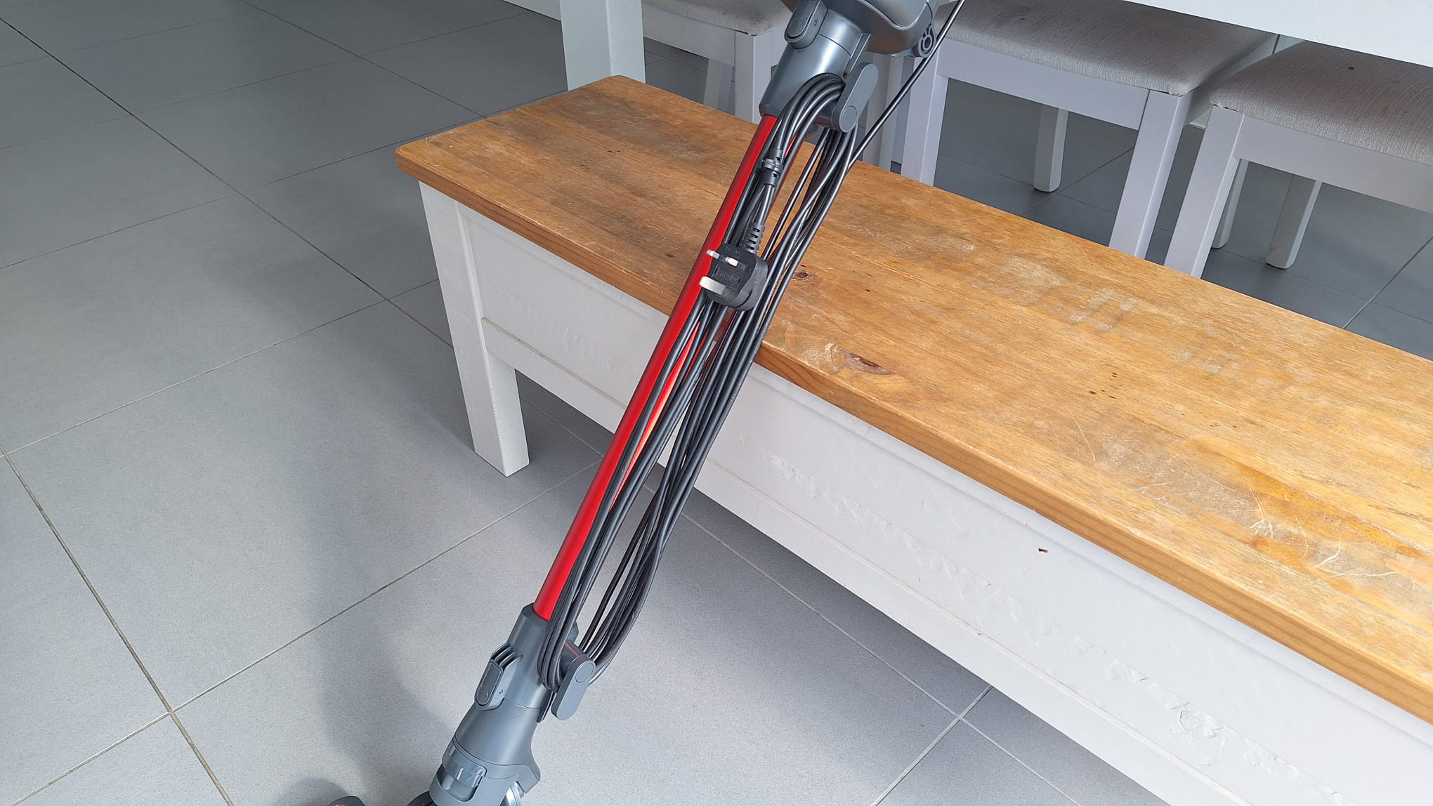 Henry Quick Corded leaning against a bench with cord wrapped neatly against the wand