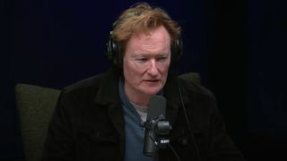 Conan O'Brien at a microphone recording Conan O'Brien Needs A Friend