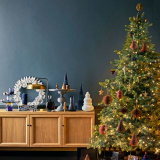 blue wall christmas tree and wooden cabinets