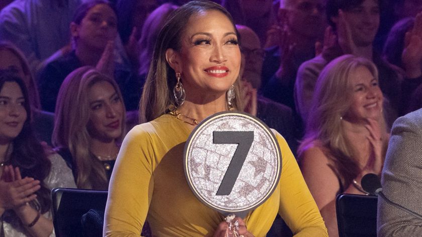 Carrie Ann holding up a 7 at the judges table