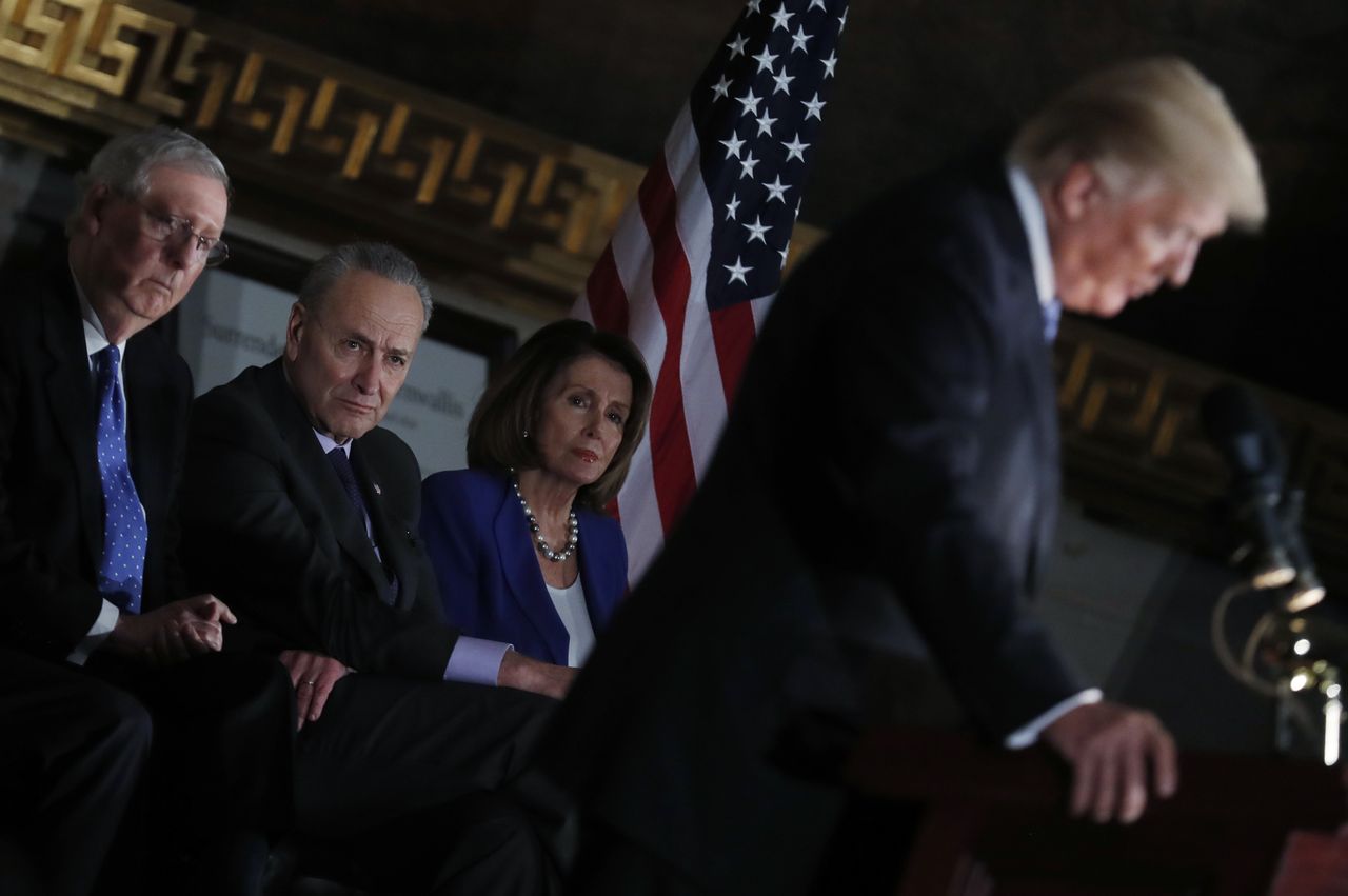 Congressional leaders watch President Trump gives a speech.