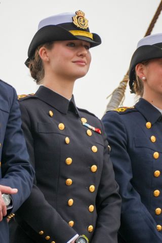 Princess Leonor wearing a military uniform and hat smiling