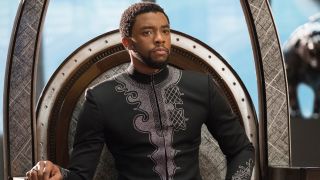 Chadwick Boseman as T'Challa sitting on a throne in Black Panther.