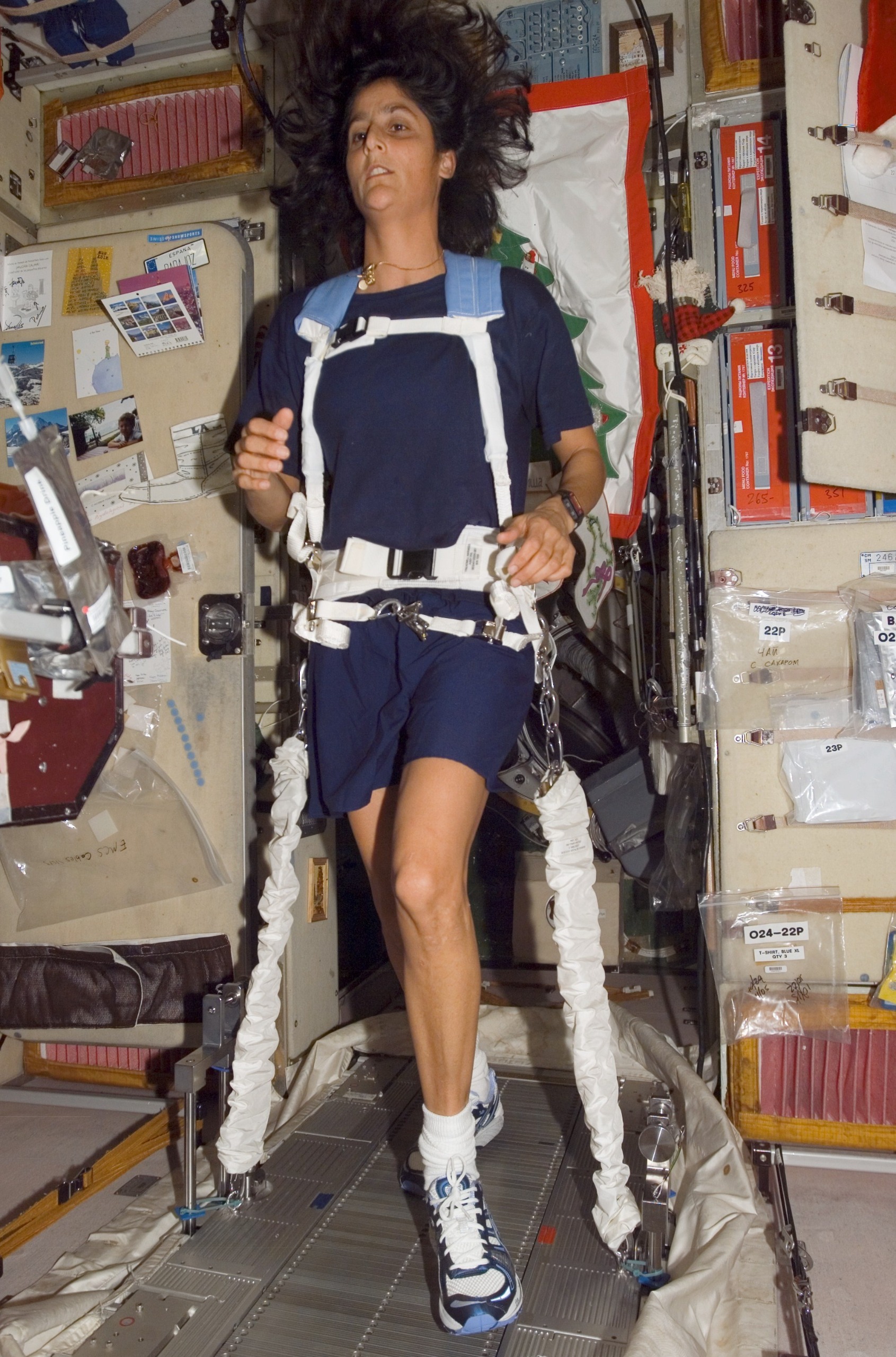 A woman walks on a treadmill in space.
