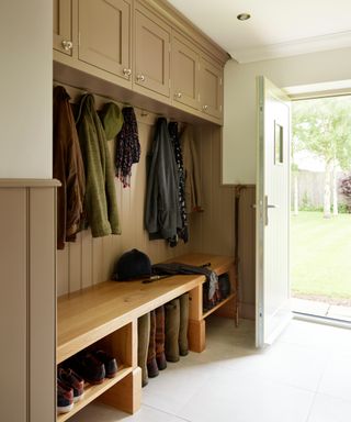 boot room with wooden seating and shelves underneath