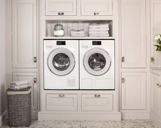 Laundry room with washer-dryers built into cupboards, off the ground